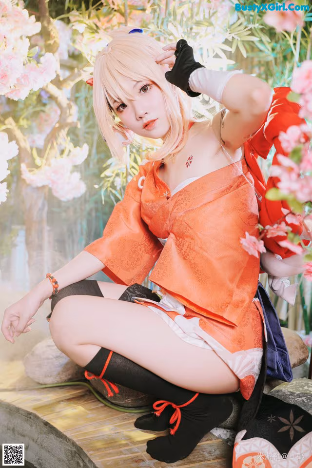 A woman in an orange kimono sitting on a wooden bench.
