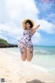 A woman jumping in the air on a beach.