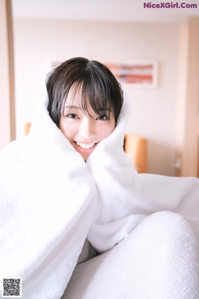 A woman wrapped up in a white towel.