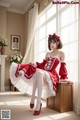 A woman in a red and white dress sitting on a wooden cabinet.