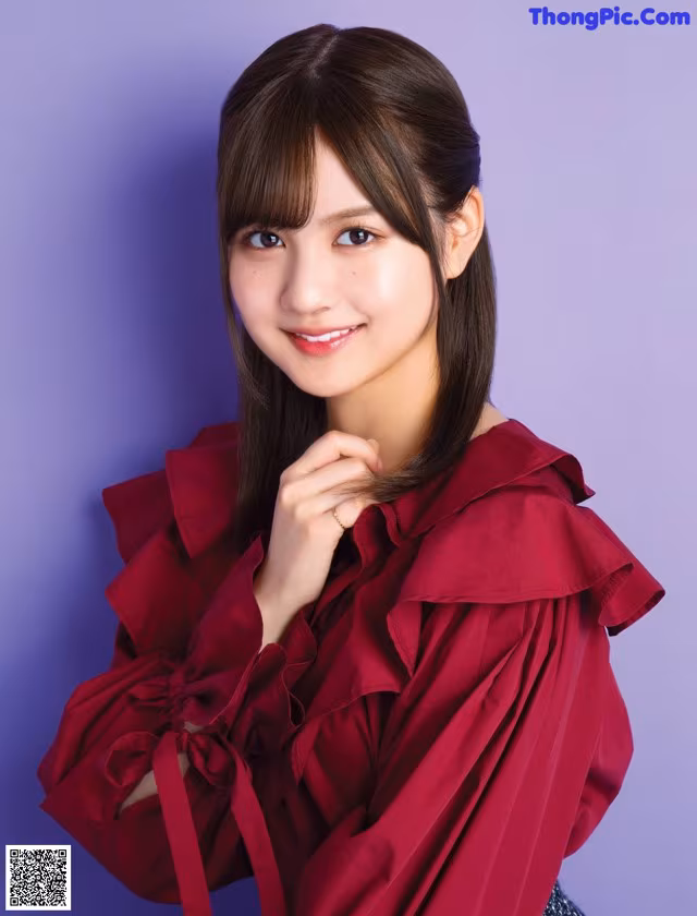 A woman in a red blouse posing for a picture.