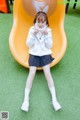 A little girl sitting on a yellow slide.