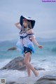 A woman in a blue and white outfit is standing in the water.