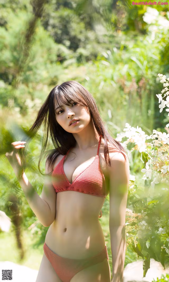 A woman in a red bikini posing for a picture.