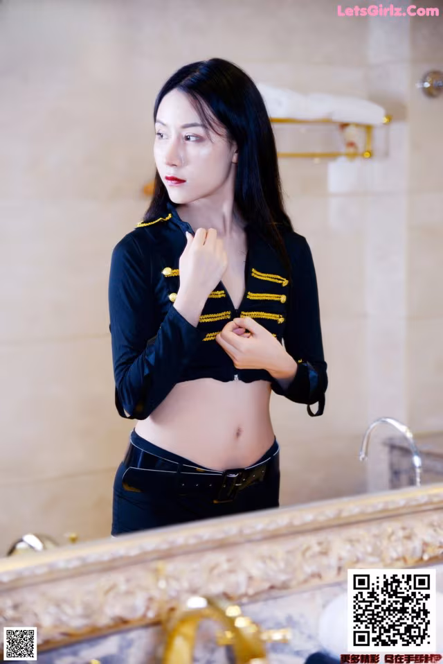 A woman standing in front of a mirror in a bathroom.