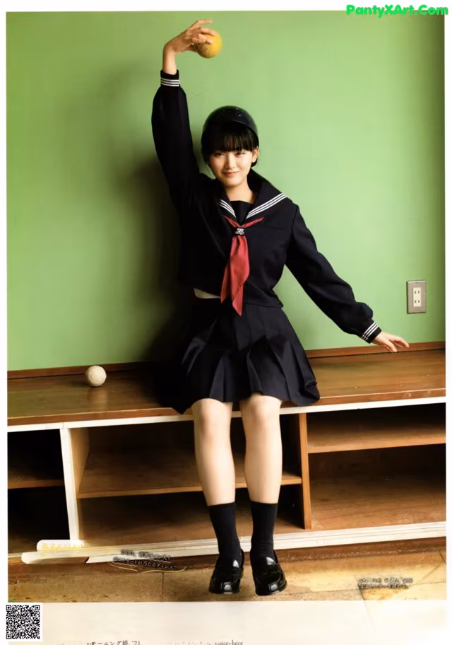 A woman in a school uniform holding a tennis ball.