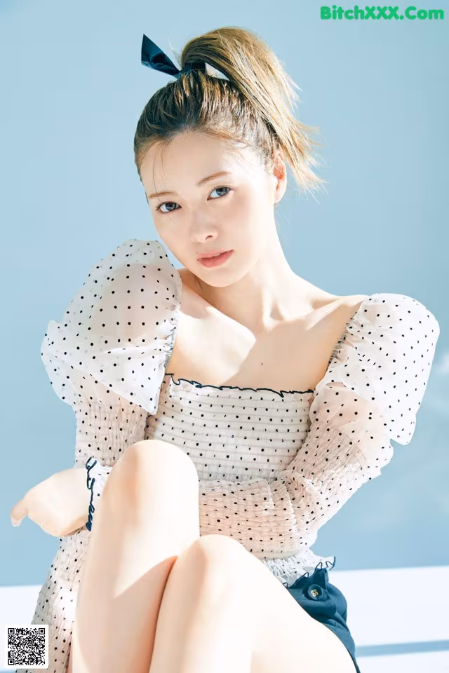 A woman sitting on top of a white table.