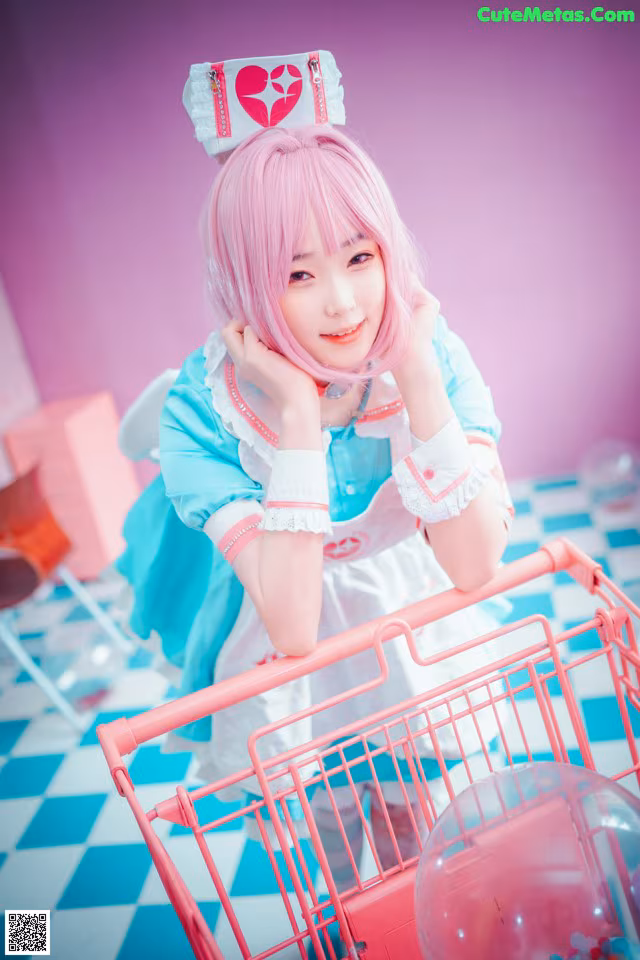 A woman with pink hair standing next to a shopping cart.