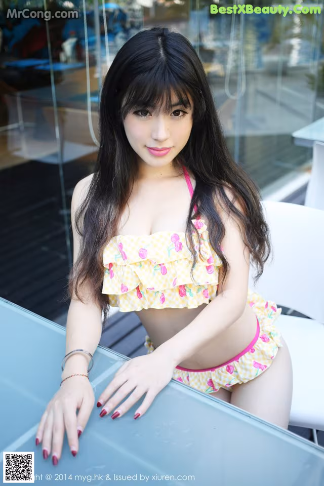 A woman in a bikini sitting at a table.