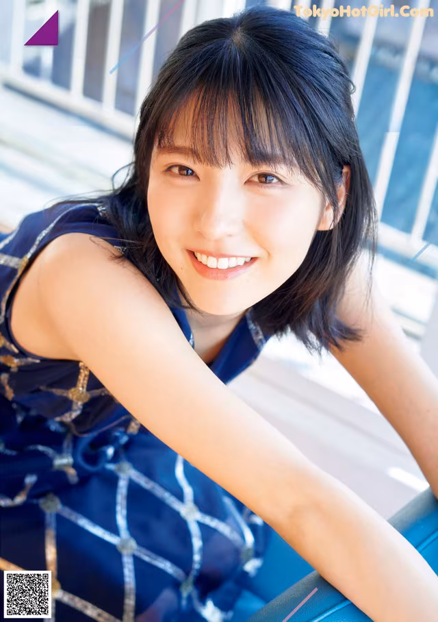 A woman in a blue dress posing for a magazine cover.