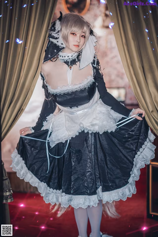 A woman dressed in a black and white maid outfit.