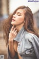 A woman in a denim jacket is posing for a picture.