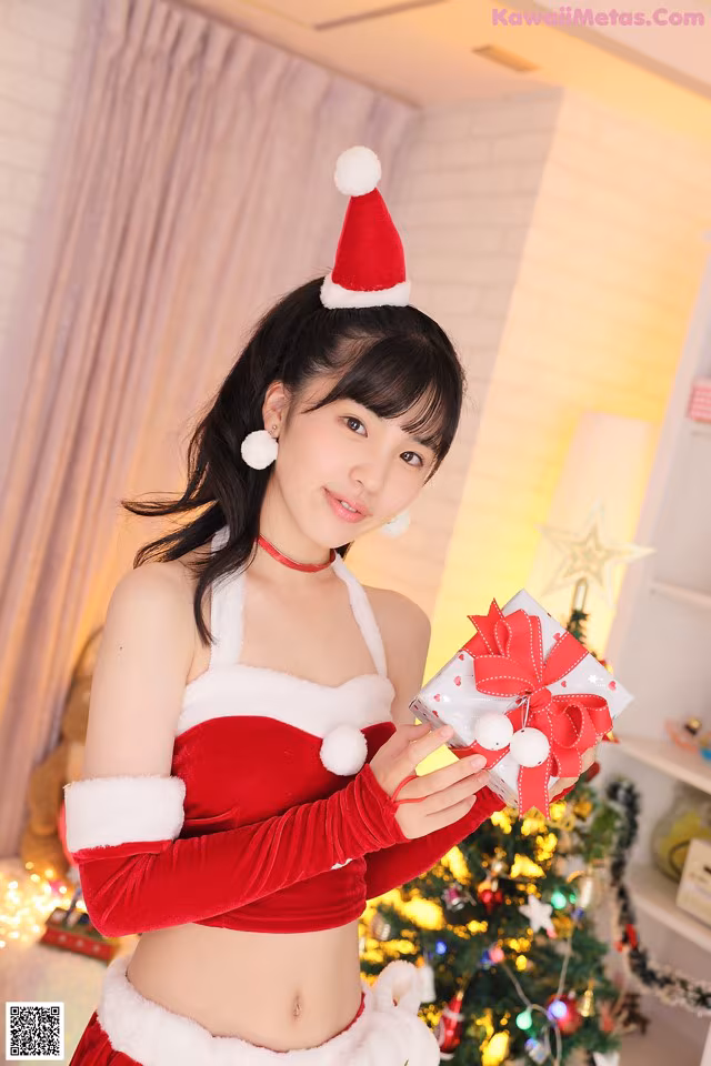 A woman in a santa outfit holding a present.